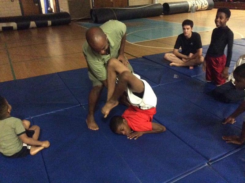 Changa Bell assists a student in scorpion pose